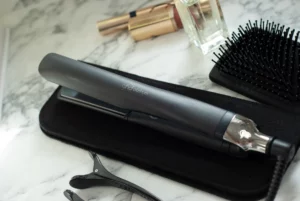 A pair of scissors and a hair brush on a marble counter