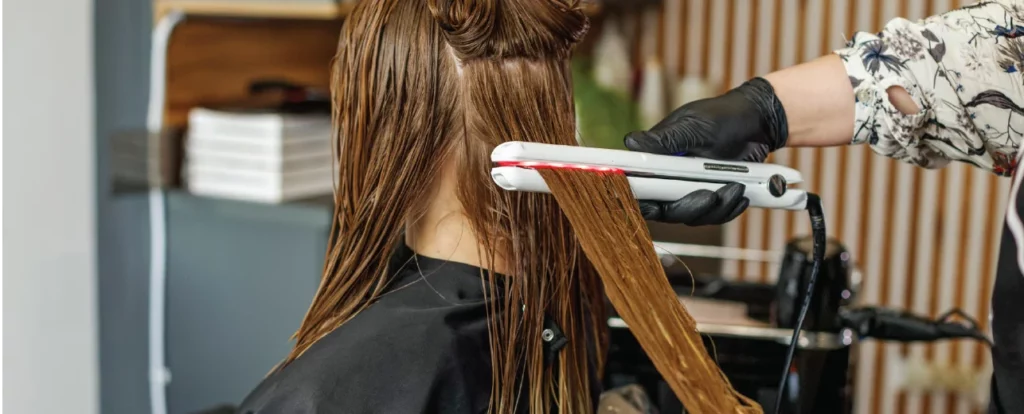 A woman getting her hair cut by a hair stylist