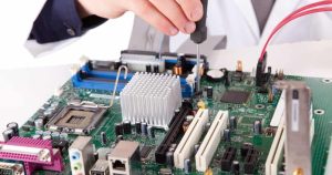 a man in a white lab coat working on a motherboard